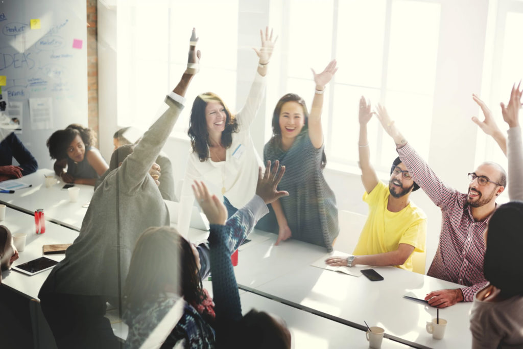 Group of raising hands in a business meeting